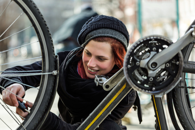 Frau repariert ihr Fahrrad