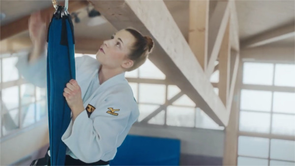 Die deutsche Judo-Weltmeisterin Theresa Stoll klettert in einer Sporthalle an einem Seil an die Decke