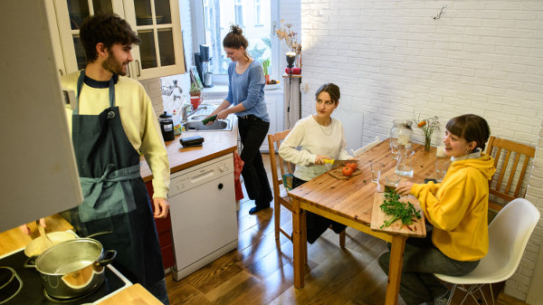 Die Studeninnen schnibbeln Gemüse, kochen und unterhalten sich dabei