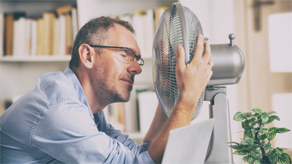 Mann kühlt sich ab vorm Ventilator