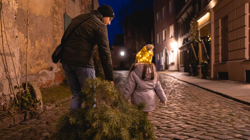 Vater und Tochter ziehen Weihnachtsbaum